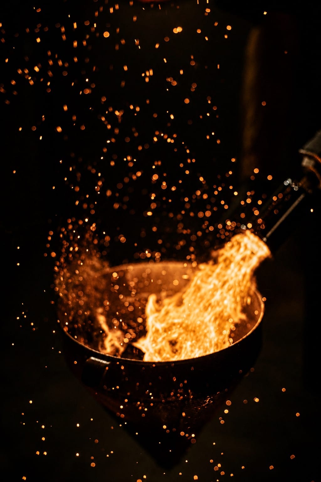 Golden embers rising against a dark background
